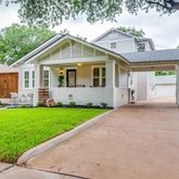 a front view of a house with a garden and trees