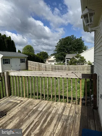 a view of a balcony with wooden floor and fence