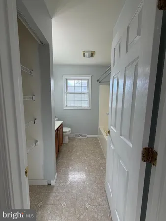 a view of an empty room with a fireplace and a window