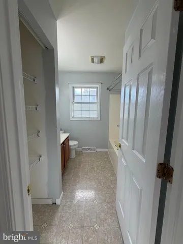a view of an empty room with a fireplace and a window