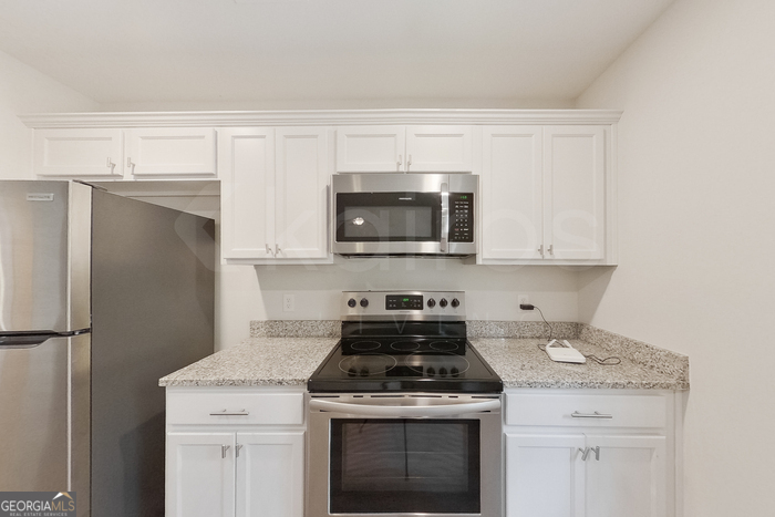 231 Western Red Cedar Drive Springfield, GA 31329 - Photo 8 of 26 a kitchen with stainless steel appliances granite countertop a stove a refrigerator and a microwave