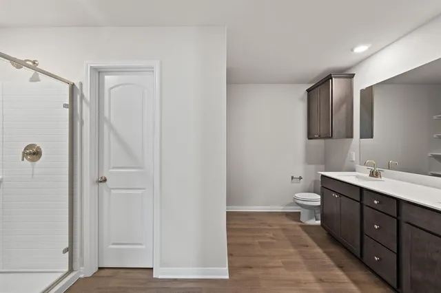a bathroom with a toilet sink double vanity and mirror