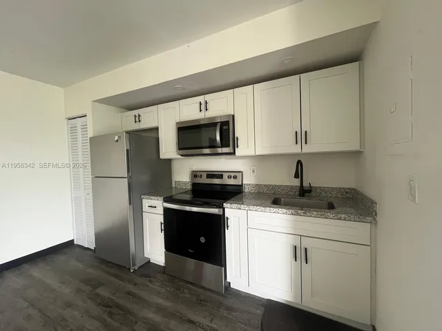 a kitchen with stainless steel appliances granite countertop a stove a sink and a refrigerator