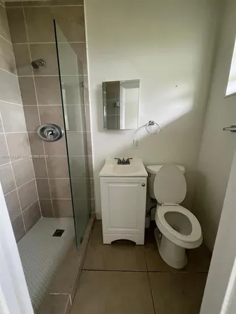 a white toilet sitting next to a bathroom sink and a shower