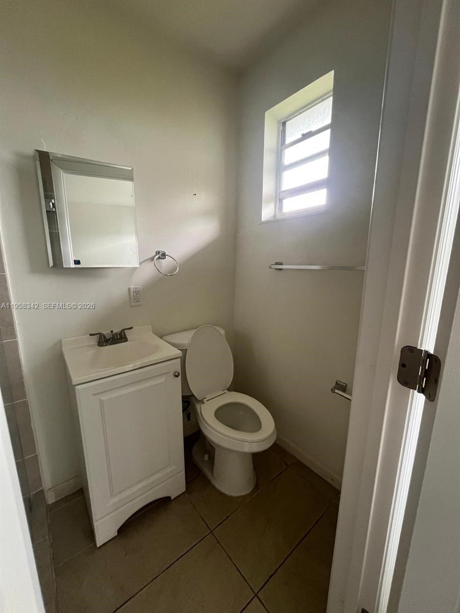 467 Northwest 8th Street, Unit 14 Miami, FL 33136 - Photo 13 of 13 a white toilet sitting next to a bathroom sink and vanity