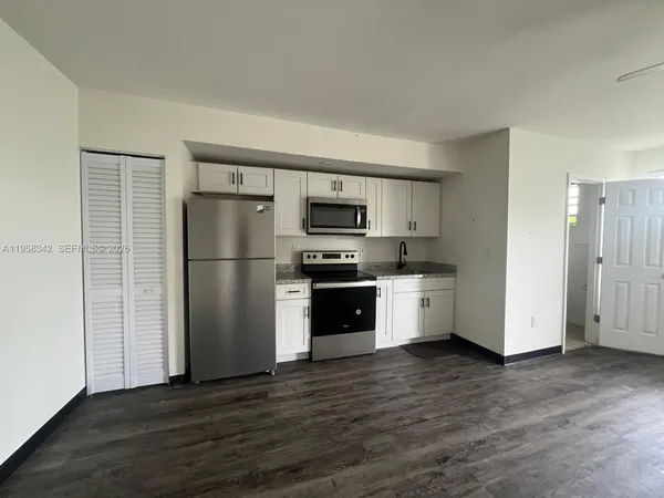 a kitchen with wooden floors and stainless steel appliances