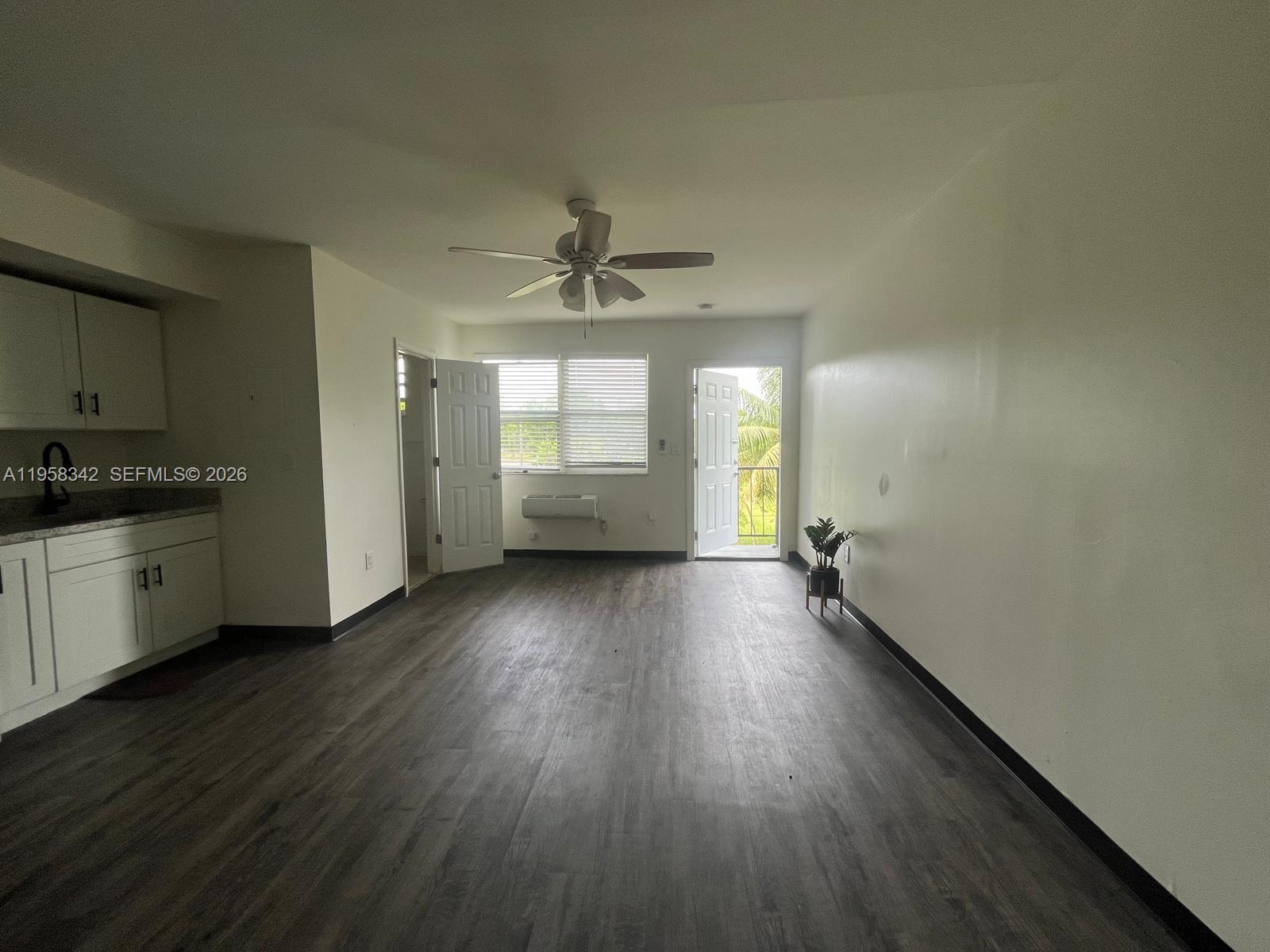 467 Northwest 8th Street, Unit 14 Miami, FL 33136 - Photo 4 of 13 an empty room with wooden floor and windows
