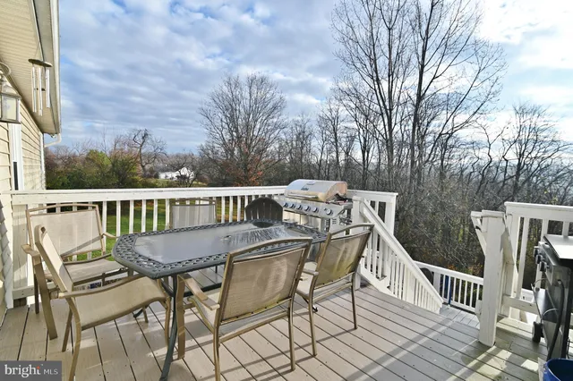 a kitchen with stainless steel appliances granite countertop a refrigerator a sink dishwasher a dining table and chairs with wooden floor