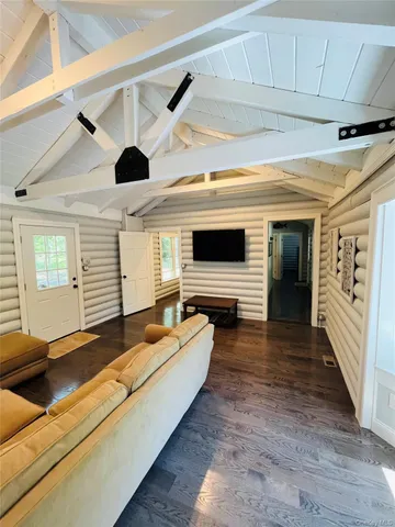 a living room with patio furniture and a flat screen tv