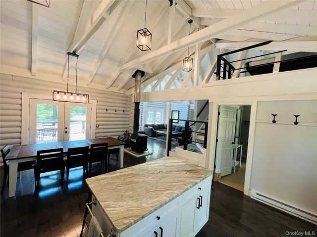 a kitchen with stainless steel appliances kitchen island a table and chairs in it