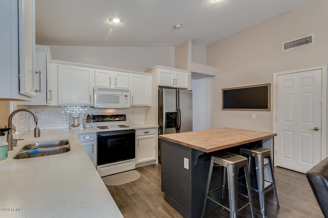 3339 East Bonanza Road Gilbert, AZ 85297 - Photo 16 of 47 a kitchen with stainless steel appliances kitchen island granite countertop a stove a sink and a refrigerator
