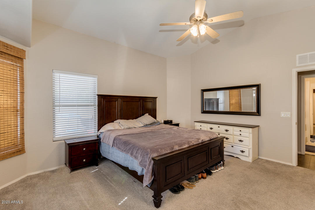 3339 East Bonanza Road Gilbert, AZ 85297 - Photo 20 of 47 a spacious bedroom with a bed and a chandelier