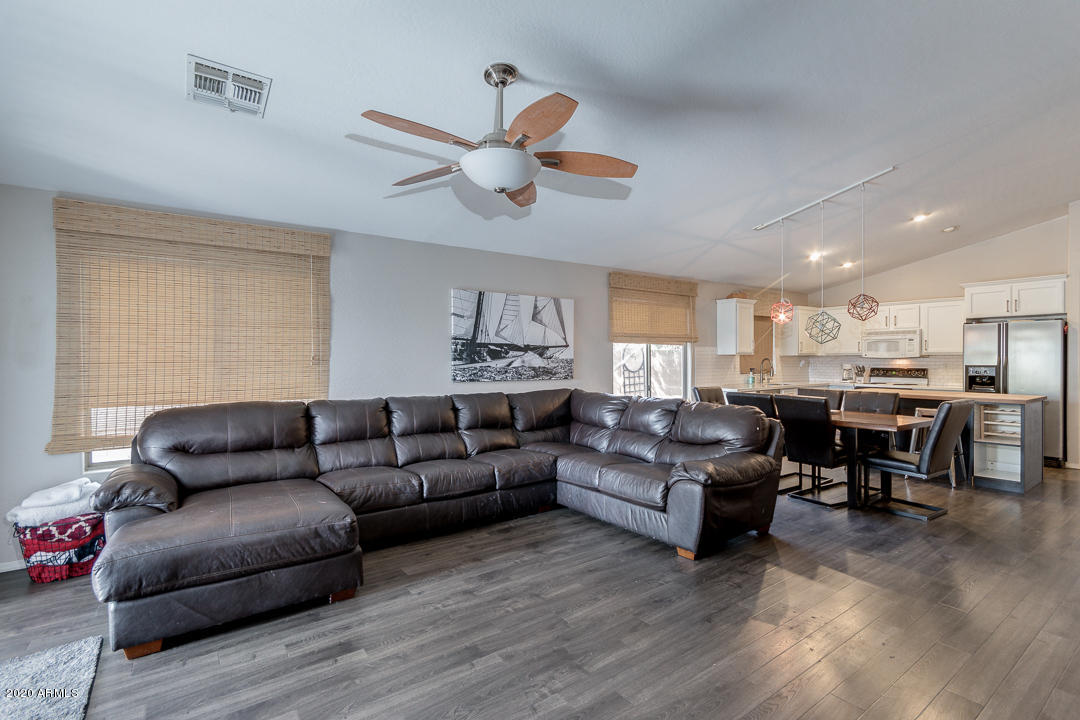 3339 East Bonanza Road Gilbert, AZ 85297 - Photo 9 of 47 a living room with couches a fireplace and kitchen view with wooden floor