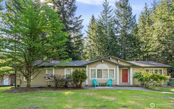 a front view of a house with a yard and trees