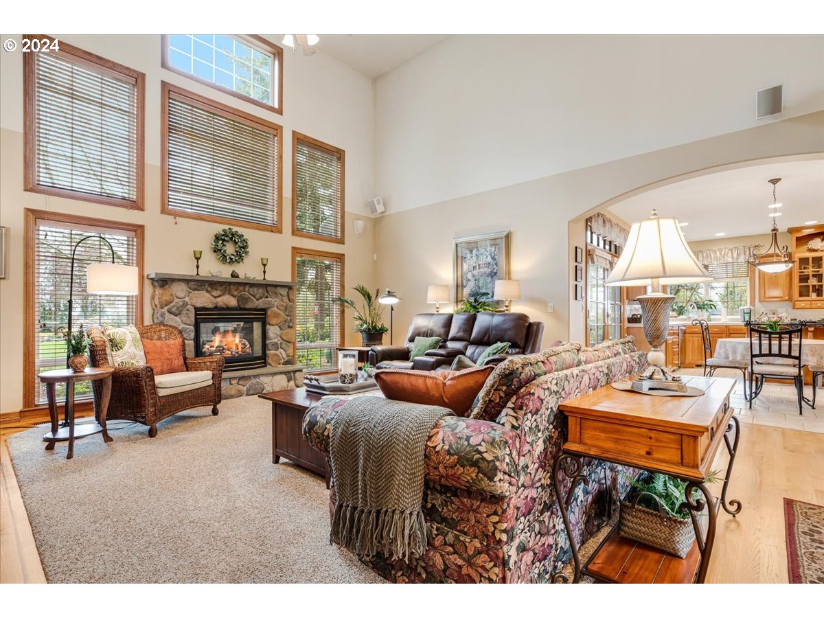 31938 Southeast Dodge Park Boulevard Gresham, OR 97080 - Photo 13 of 48 a living room with furniture a fireplace and large windows