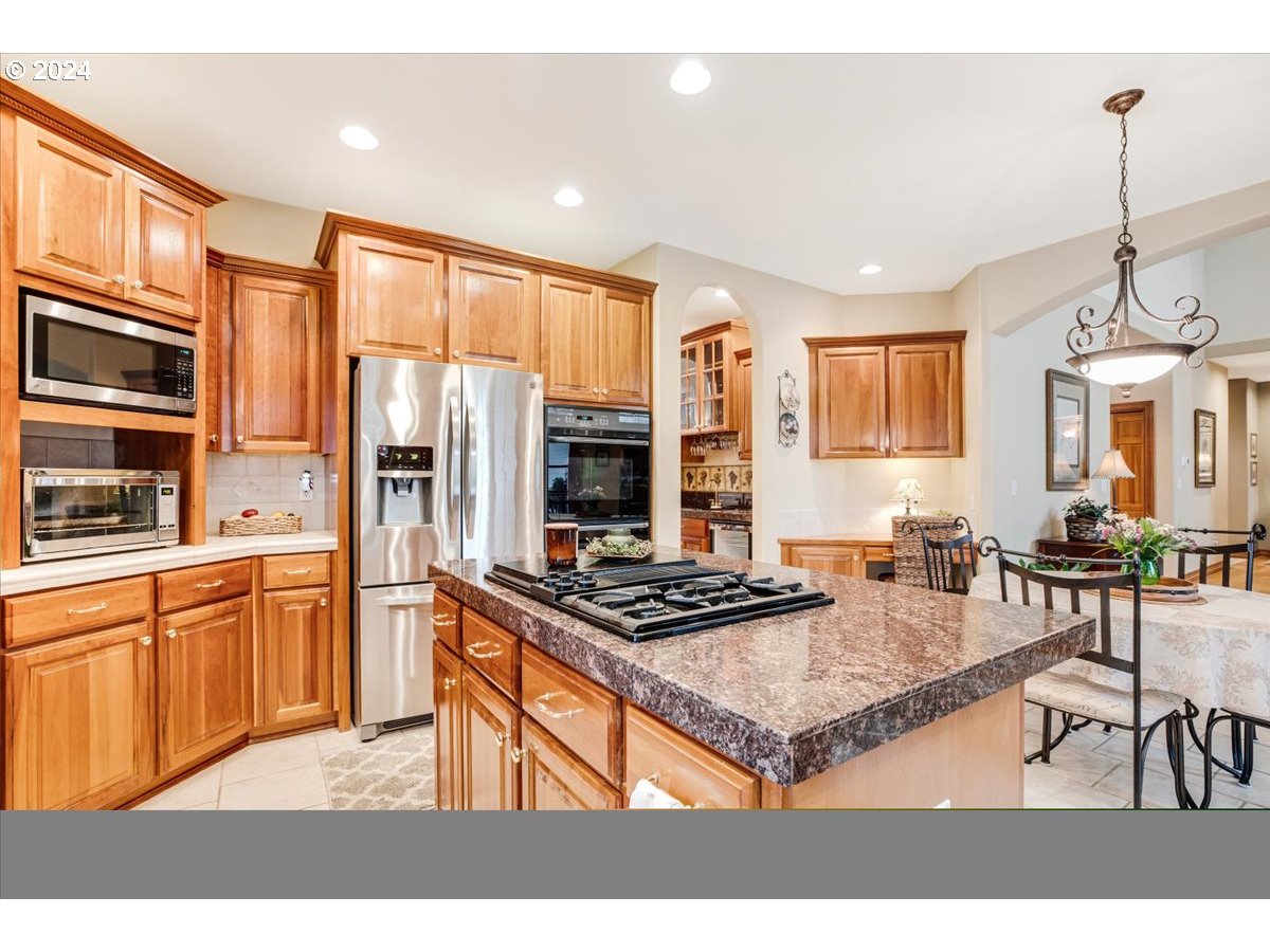 31938 Southeast Dodge Park Boulevard Gresham, OR 97080 - Photo 21 of 48 a kitchen with stainless steel appliances granite countertop a stove a sink dishwasher and a refrigerator with wooden cabinets