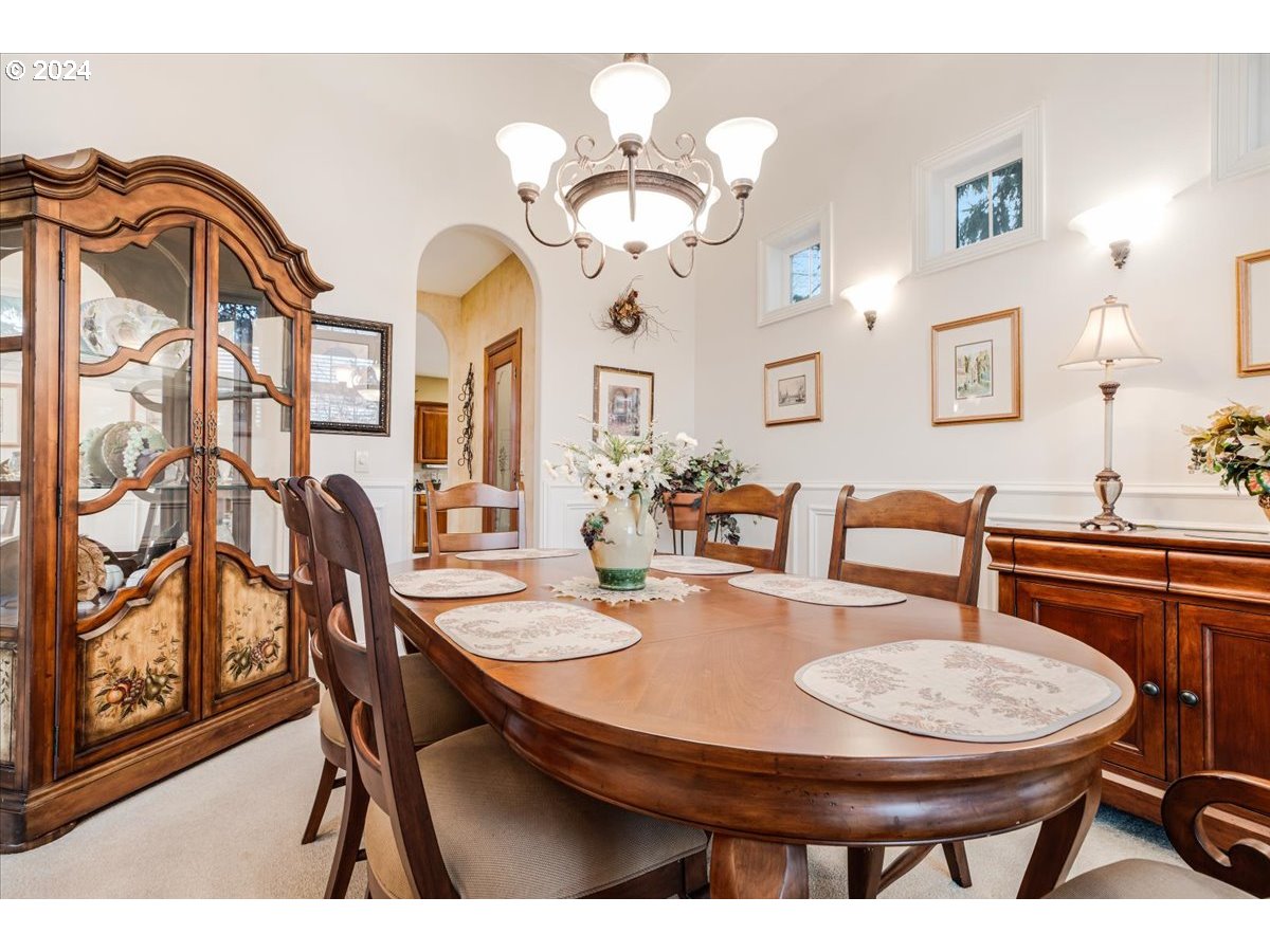 31938 Southeast Dodge Park Boulevard Gresham, OR 97080 - Photo 8 of 48 a dining room with wooden floor a chandelier a wooden table and chairs