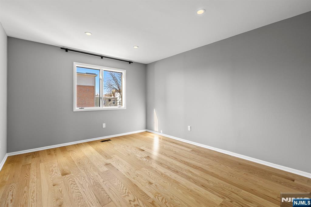 319 Gorge Road, Unit 6 Cliffside Park, NJ 07010 - Photo 16 of 24 an empty room with wooden floor and windows