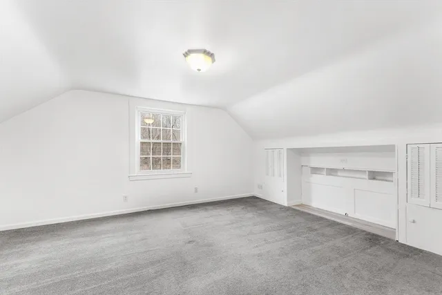 an empty room with windows and cabinet