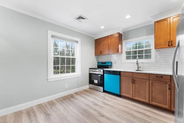 a kitchen with stainless steel appliances granite countertop a stove a sink and a refrigerator