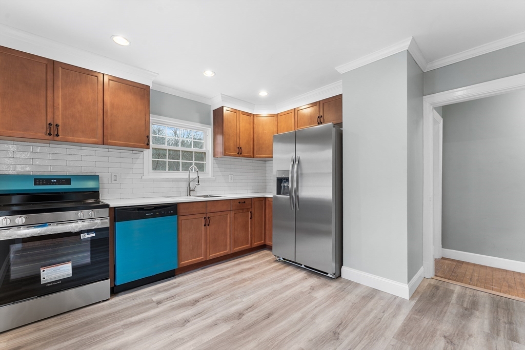 127 Old Millville Road Uxbridge, MA 01569 - Photo 10 of 30 a kitchen with stainless steel appliances granite countertop a refrigerator a stove and a sink with wooden floor