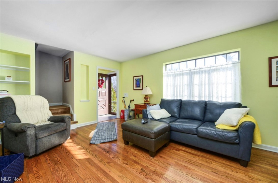 15902 Munn Road Cleveland, OH 44111 - Photo 5 of 27 Living room with a wealth of natural light, built in shelves, and hardwood / wood-style flooring
