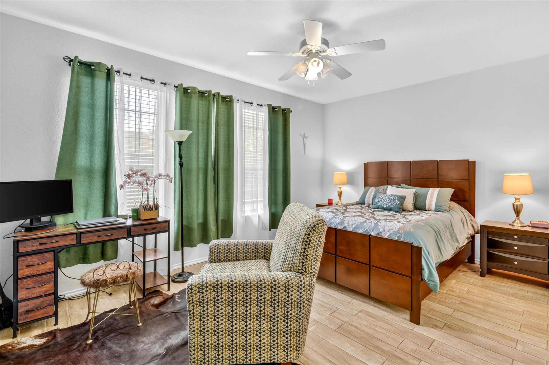 460 Waterleaf Boulevard Kyle, TX 78640 - Photo 12 of 30 Well-lit sleeping quarters with rich wooden furniture and a comfortable armchair for quiet contemplation.