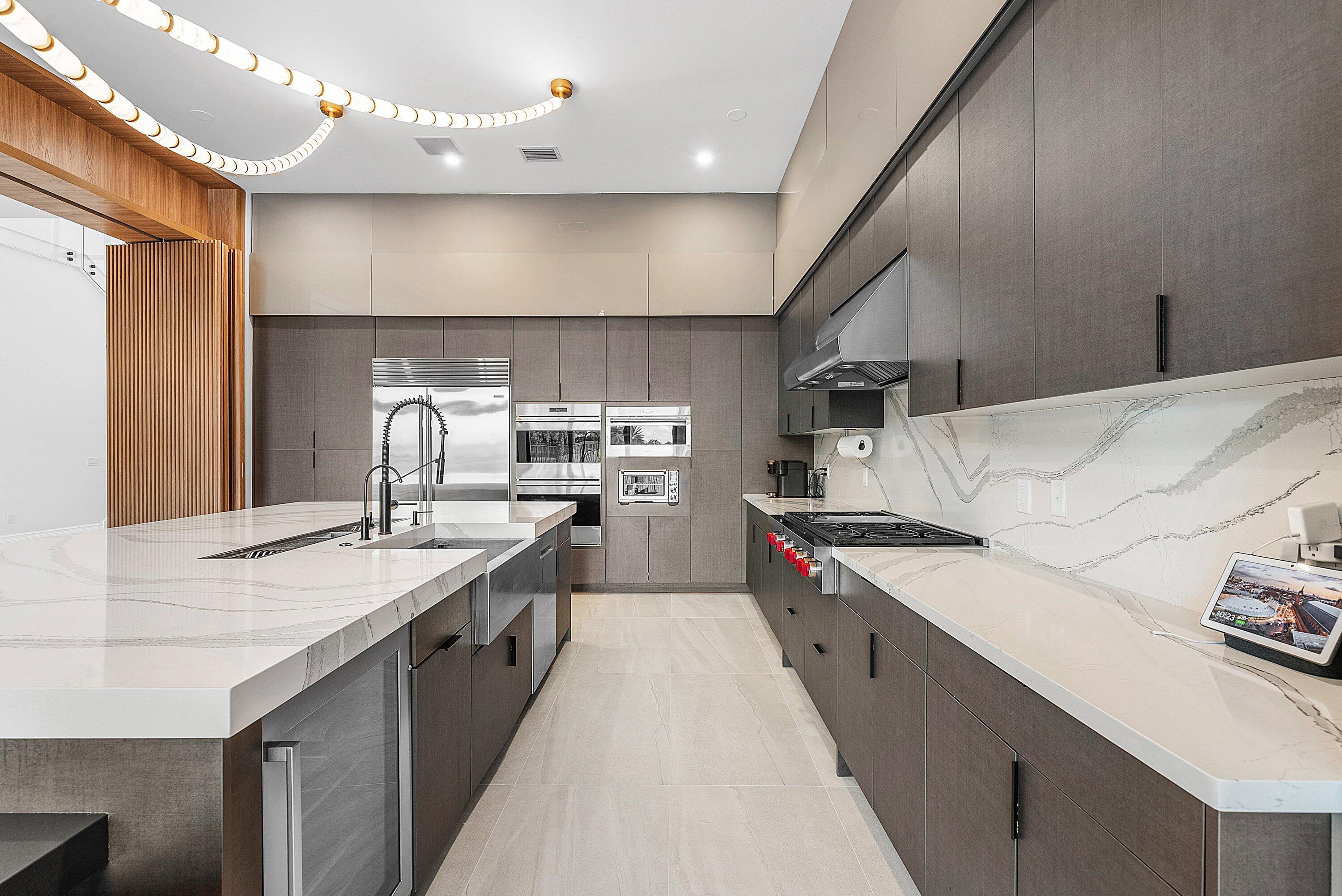 17353 Rosella Road Boca Raton, FL 33496 - Photo 19 of 77 a large kitchen with stainless steel appliances kitchen island a large counter top a stove a chimney a sink and a refrigerator