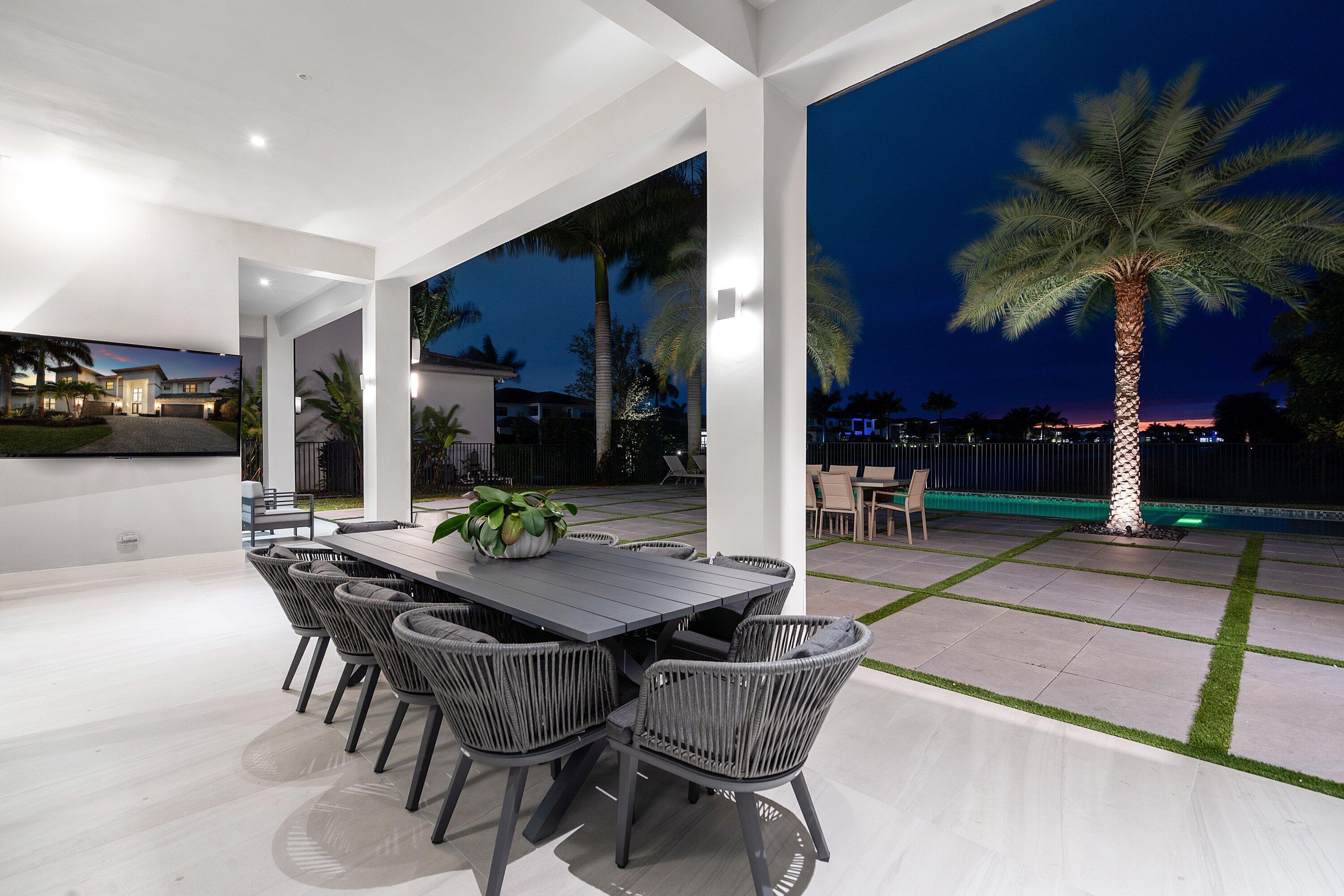 17353 Rosella Road Boca Raton, FL 33496 - Photo 65 of 77 a view of a patio with dining table and chairs under an umbrella