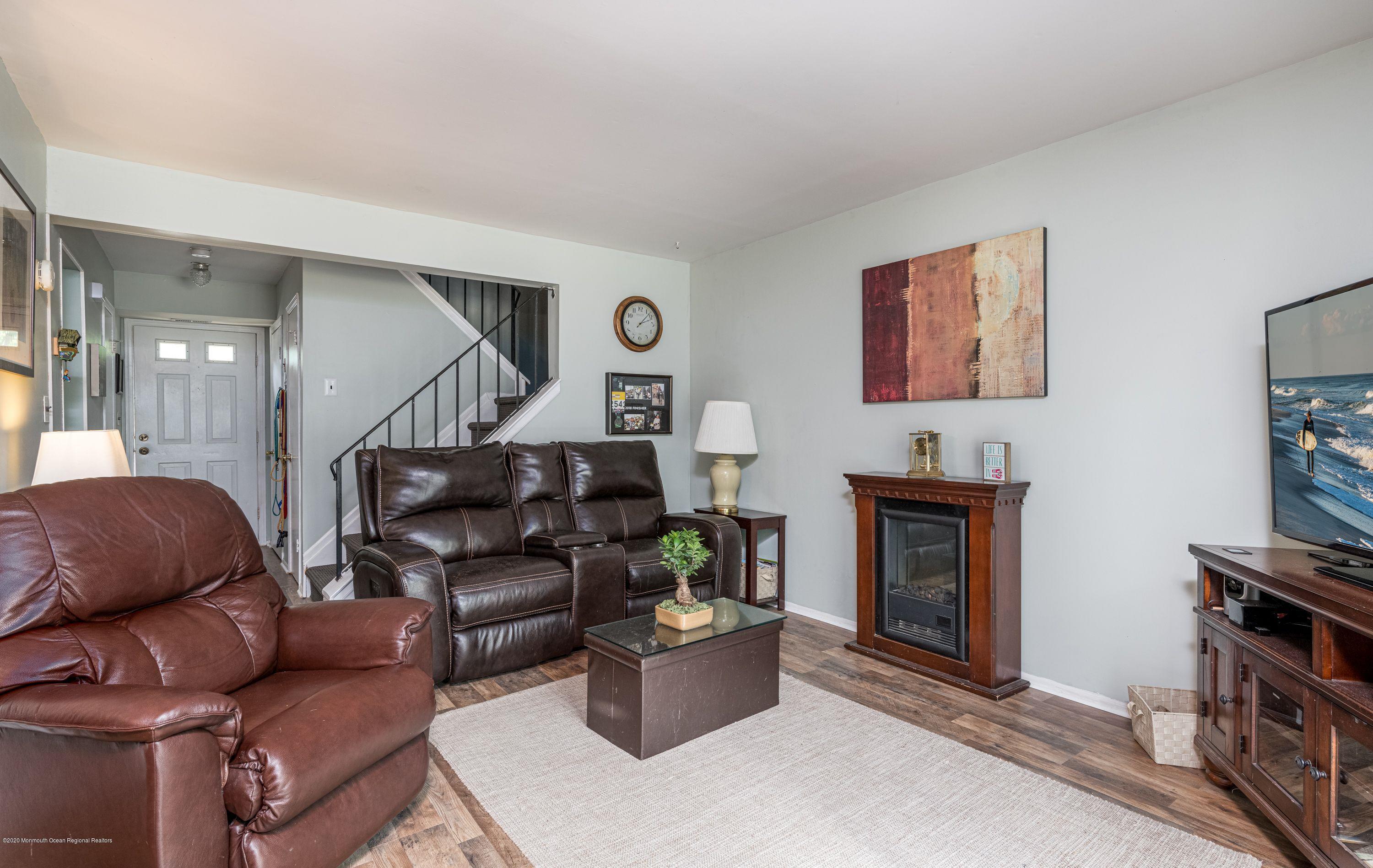 15 Finch Road Howell, NJ 07731 - Photo 5 of 15 a living room with furniture a flat screen tv and a fireplace