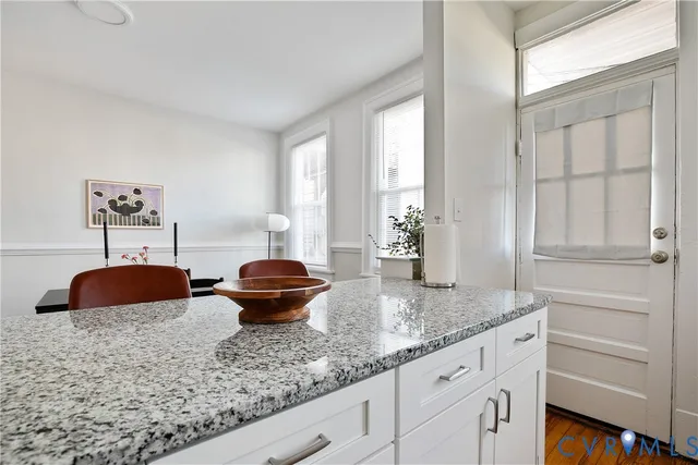 a view of a hallway with wooden floor and a bathroom