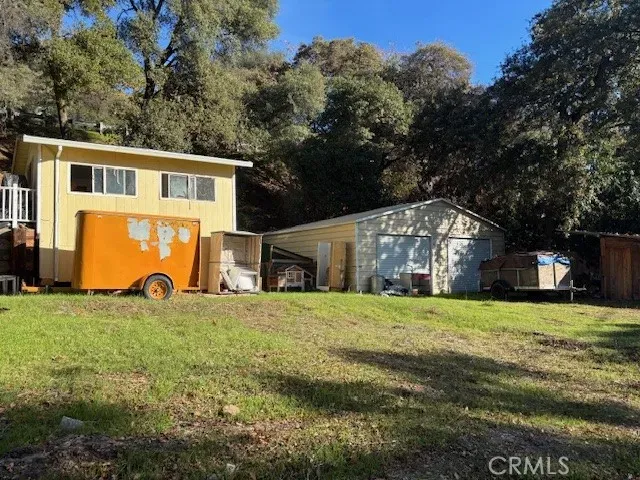 a view of a house with a yard and large tree