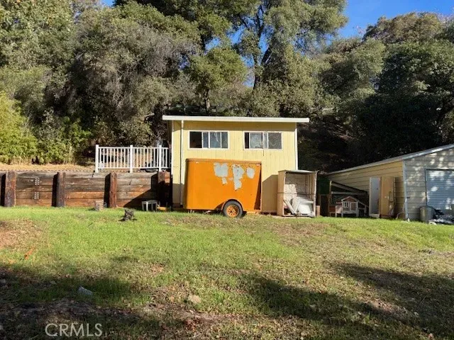 a view of a house with a big yard and large tree