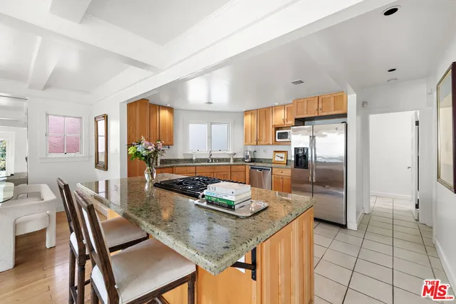 a kitchen with granite countertop kitchen island stainless steel appliances a table and chairs