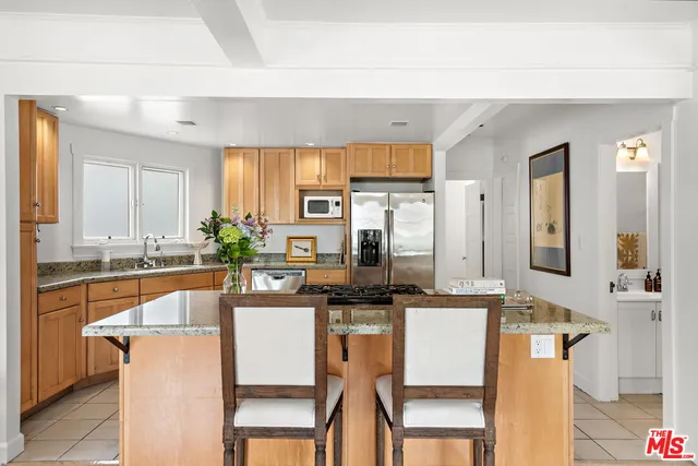 a kitchen with stainless steel appliances granite countertop a sink and a refrigerator