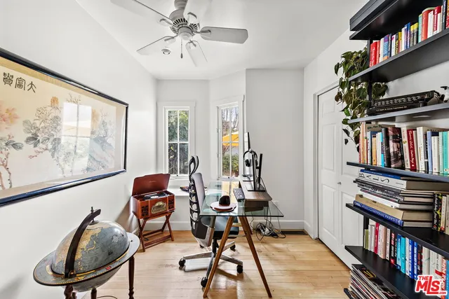 a view of a workspace with furniture and a book shelf
