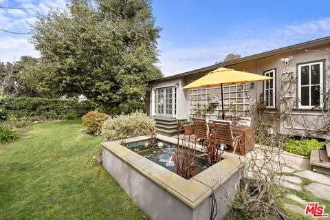 a view of a house with backyard and sitting area