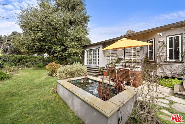 a view of a house with backyard and sitting area