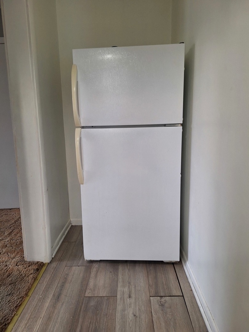 214 South Bloomington Street, Unit 3 Streator, IL 61364 - Photo 6 of 10 a view of a small space with wooden floor and a refrigerator