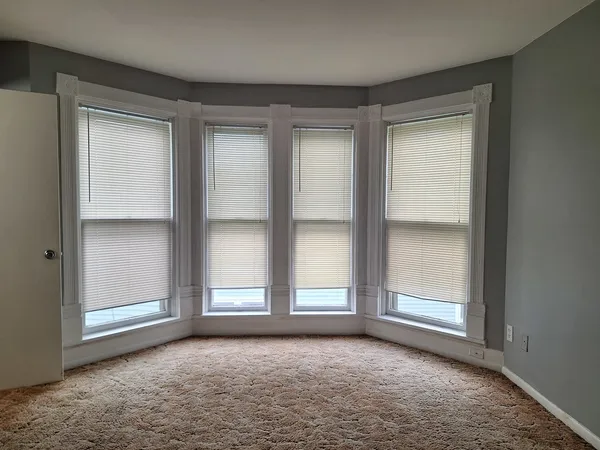an empty room with windows and closet
