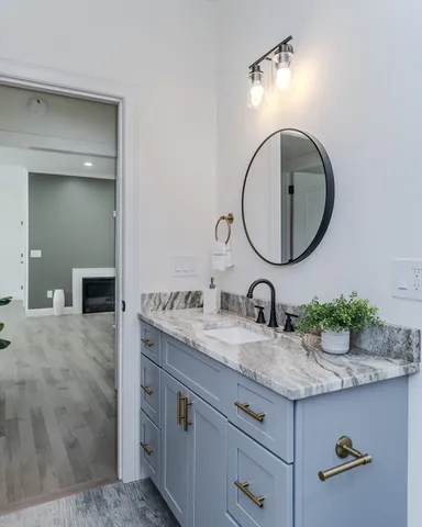 a bathroom with a granite countertop sink and a mirror