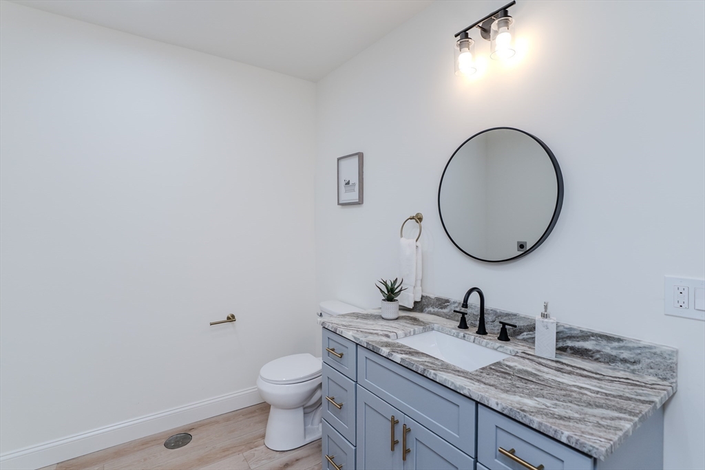 135 Thompson Street Palmer, MA 01069 - Photo 30 of 39 a bathroom with a granite countertop toilet a sink and a mirror