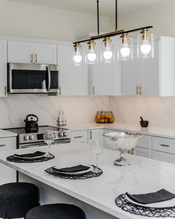 135 Thompson Street Palmer, MA 01069 - Photo 5 of 39 a kitchen with kitchen island a stove and a sink