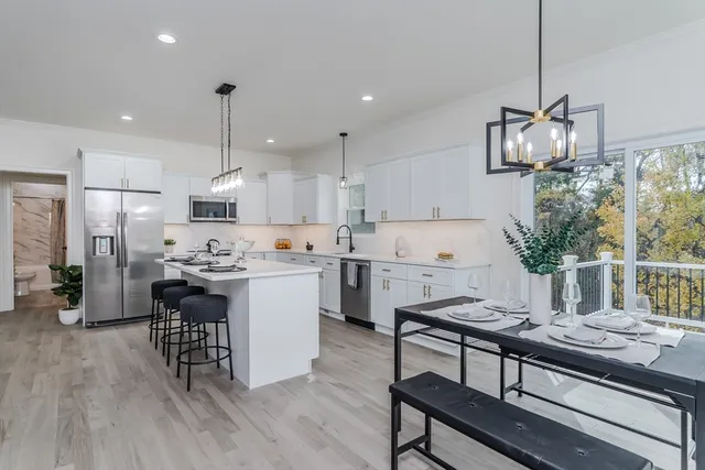 a kitchen with a table chairs microwave and cabinets