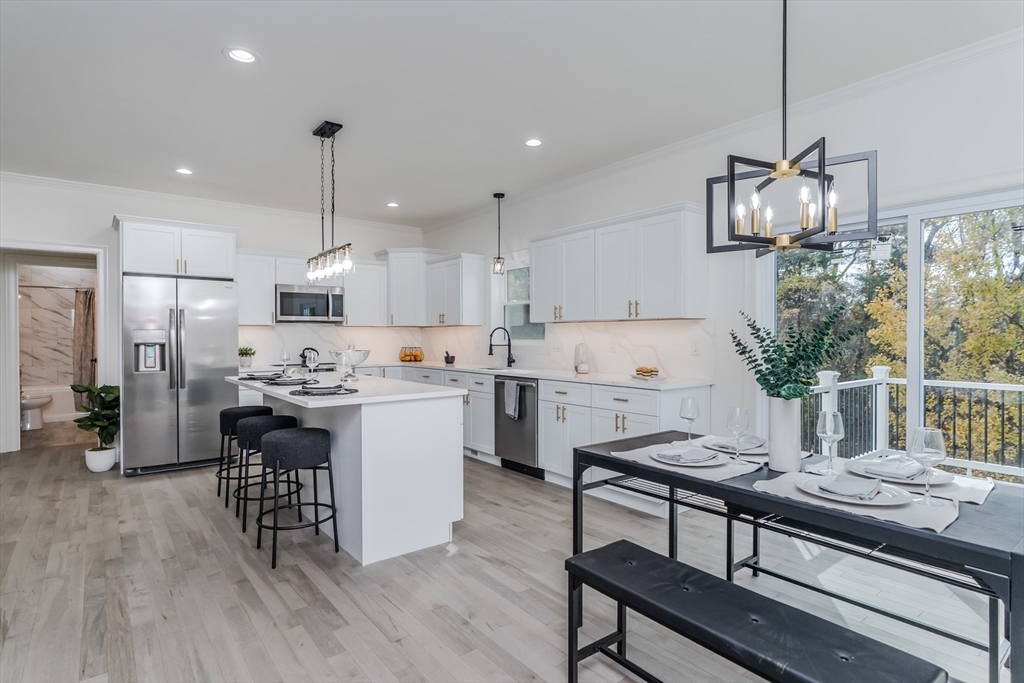 135 Thompson Street Palmer, MA 01069 - Photo 8 of 39 a kitchen with a table chairs microwave and cabinets
