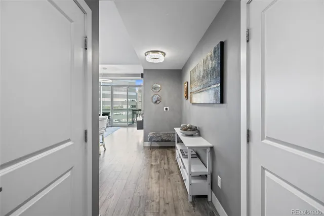 a view of a hallway with wooden floor and a bathroom