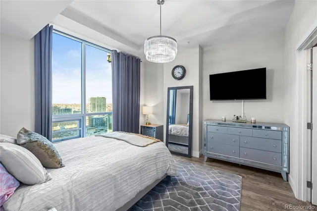 a bedroom with a bed and a flat tv screen on the dresser
