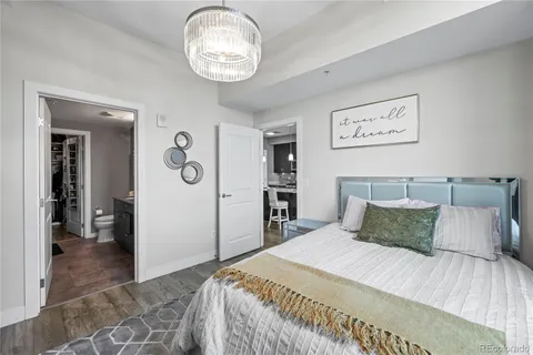 a bedroom with a large bed and a chandelier