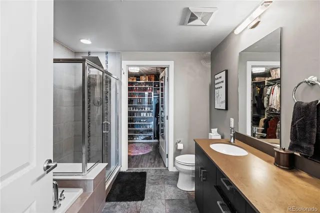 a bathroom with a double vanity sink a toilet a mirror and shower