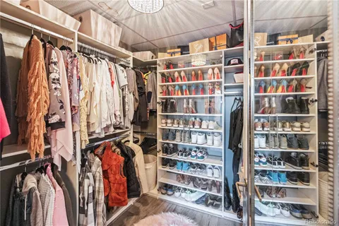 a view of walk in closet with clothes and shoes